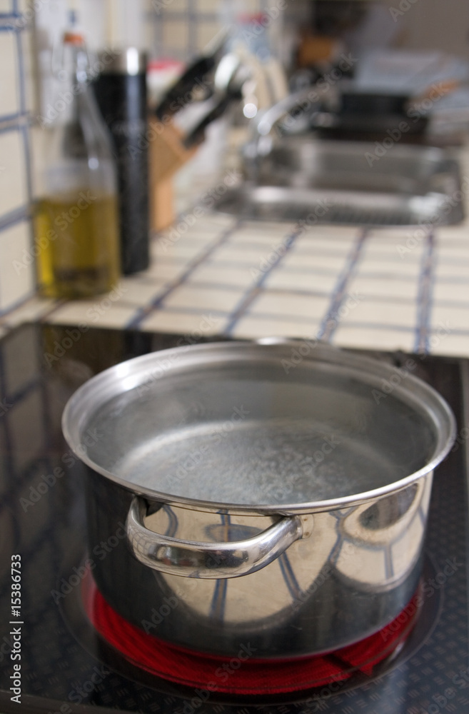 Metal pan with water on a hotplate in a domestic kitchen Metal pan with water on a hotplate in a domestic kitchen