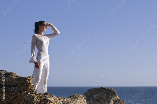 Frau steht auf einem Felsen