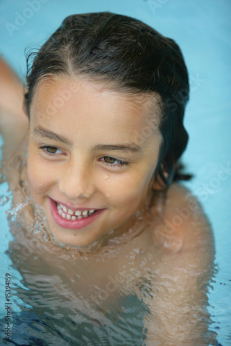 Portrait d'un petit garçon souriant à la piscine