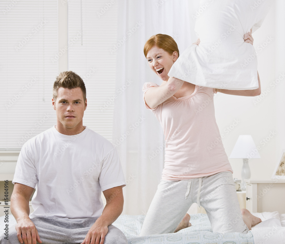 Fototapeta premium Attractive Couple Playing Around with a Pillow Fight
