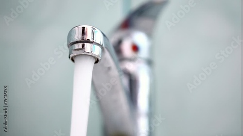 Man's hand starting and stopping tap water in bathroom