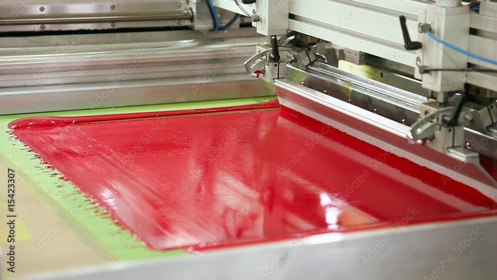 Screen printing machine working, printing magenta