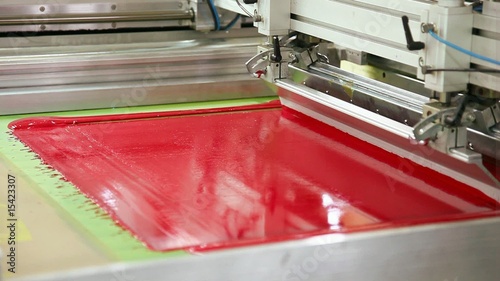 Screen printing machine working, printing magenta