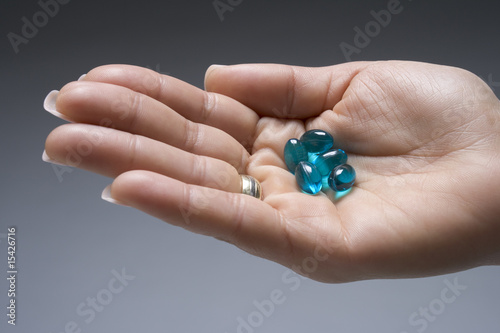 Hand full of blue capsules