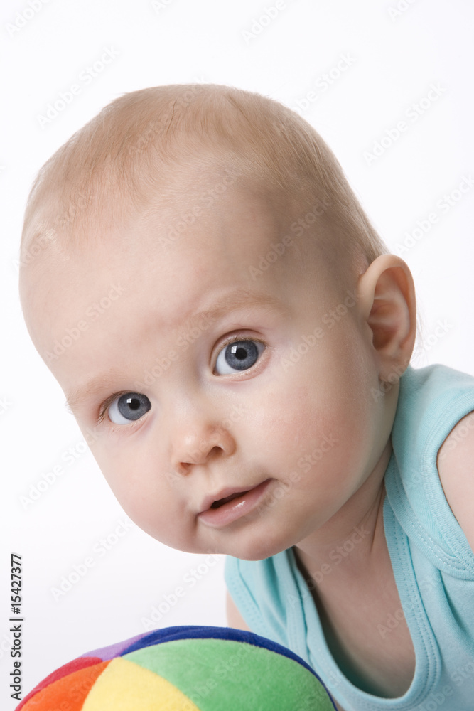 Portrait of a baby boy with a soft colored toy ball