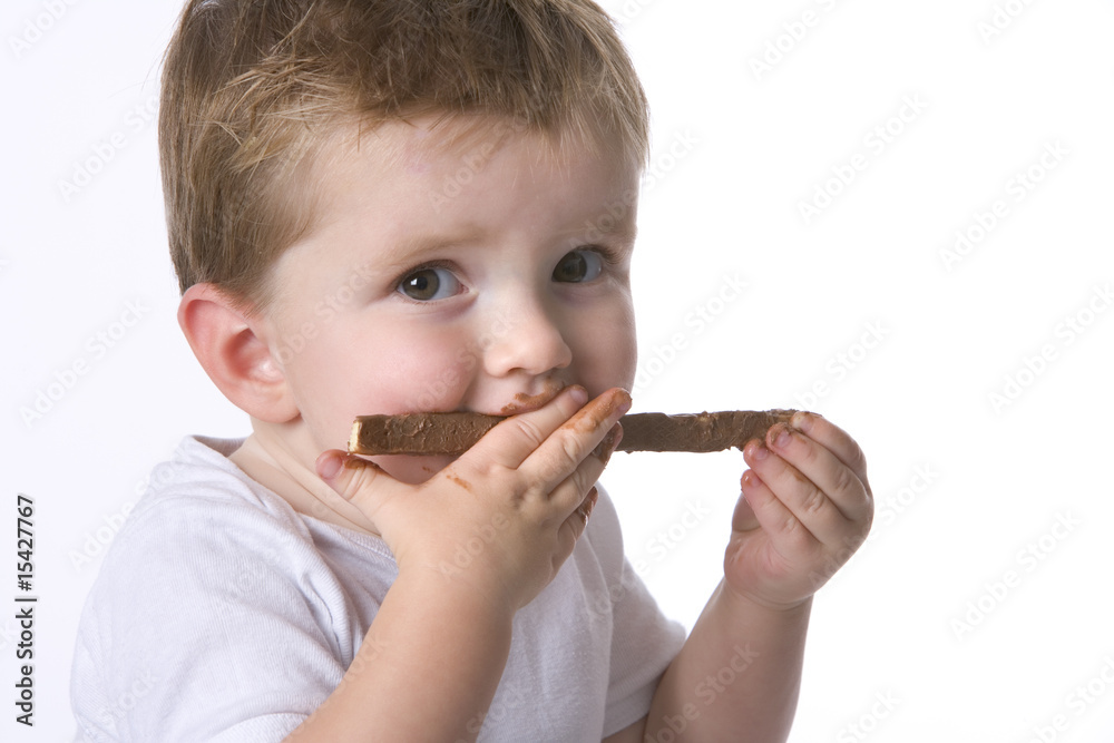 Toddler boy is eating chocolate Toddler boy is eating chocolate