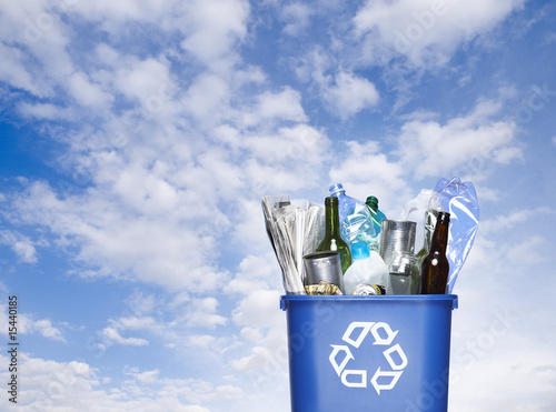 Blue recycling bin against sky background