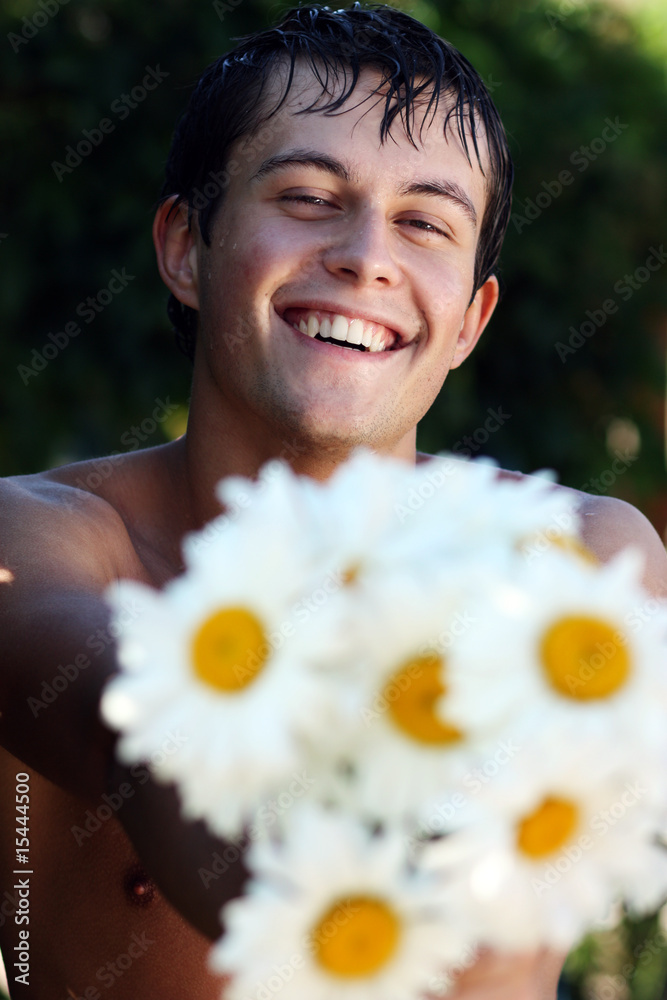 beautiful guy with a bouquet of camomiles