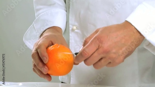 Cuoco sbuccia un arancio photo