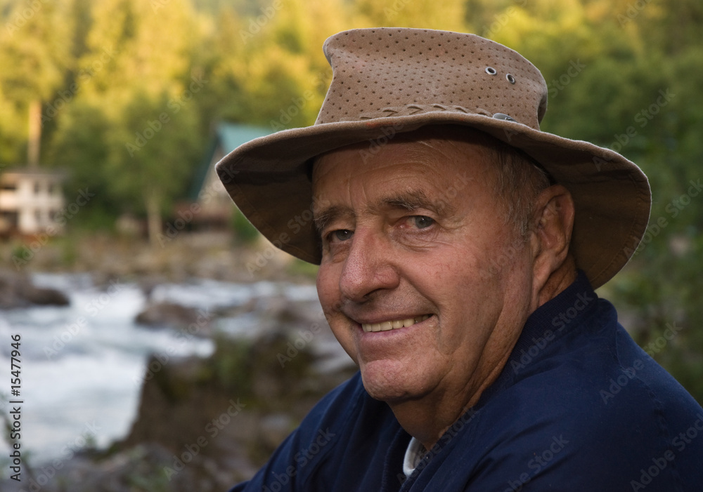Senior male fisherman with river in background