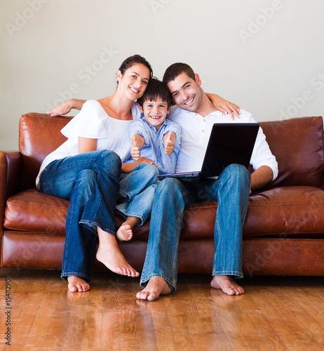 Happy family using a laptop with thumbs up