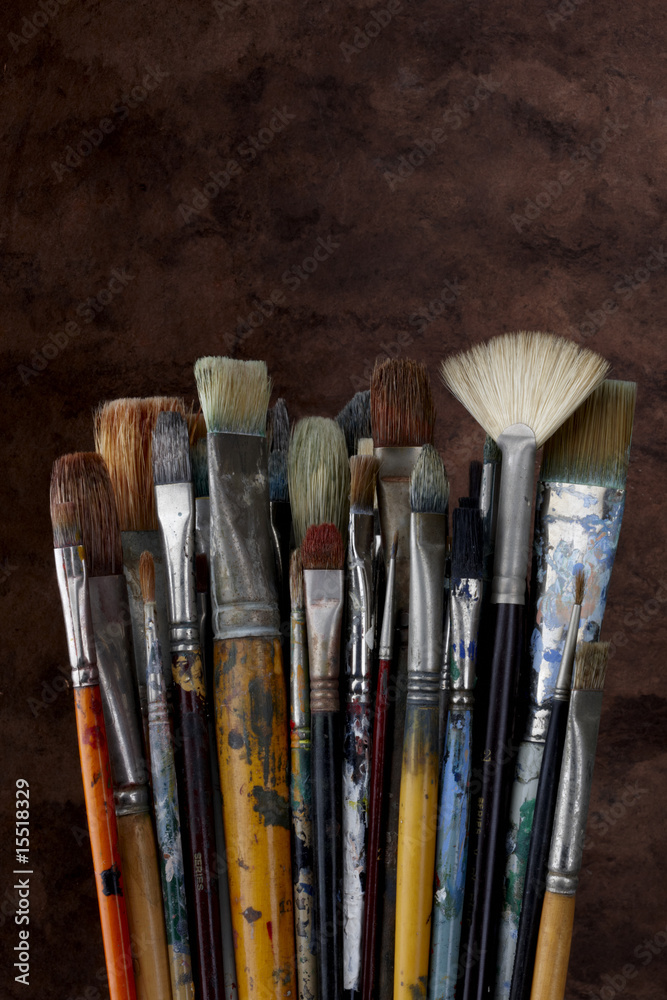 Fototapeta premium Artist paint brushes shot with dark textured background