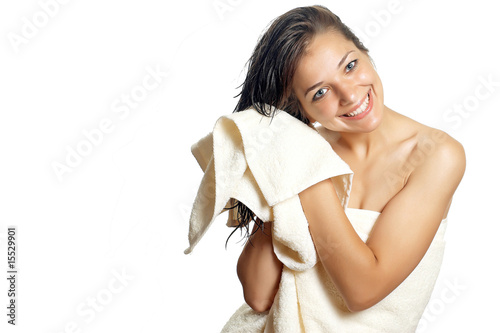 Beautiful woman in white towel wipes her wet hair with a towel