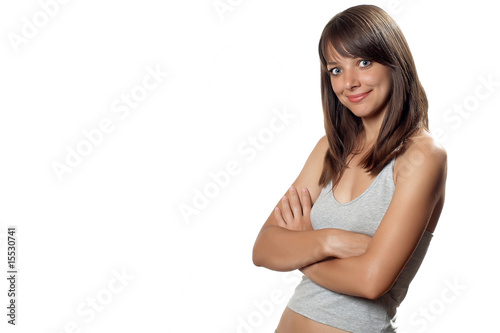 Young happy woman in grey shirt with hands near hip