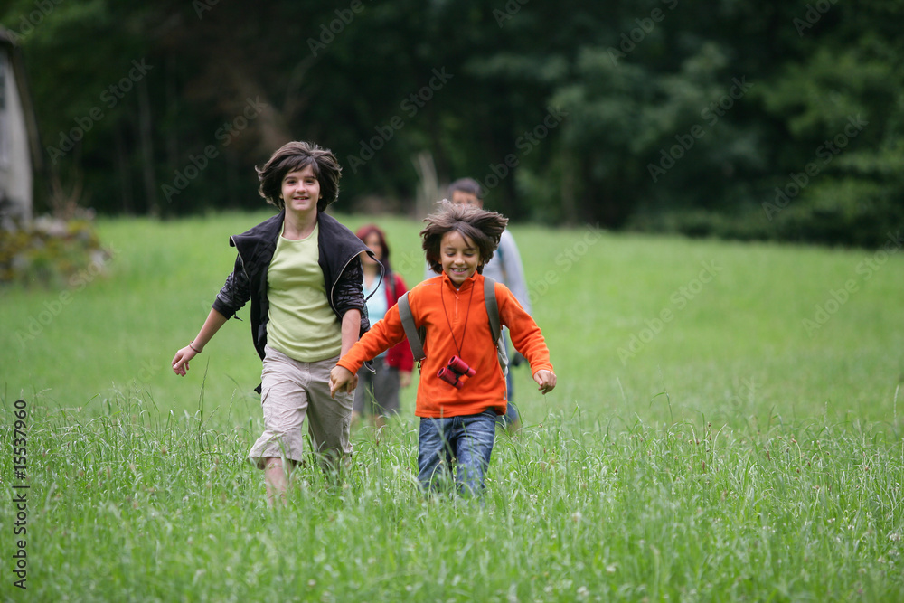 Jeunes enfants souriants courant en se tenant la main Jeunes enfants souriants courant en se tenant la main