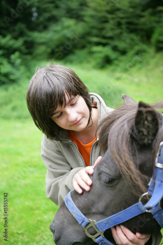 Portrait d'une jeune fille caressant un cheval