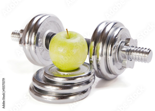 Dumbbells  and green apple  on white background