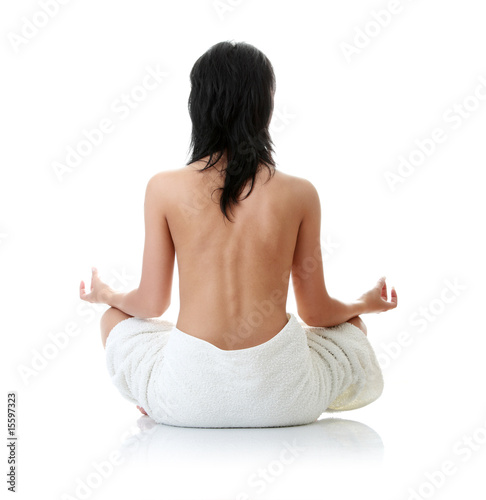 Back of a nude beautiful woman meditating