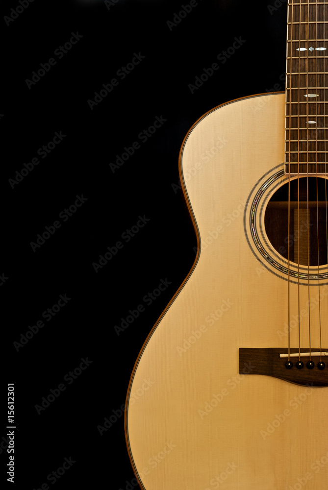 Fototapeta premium Acoustic guitar shown against a black background.