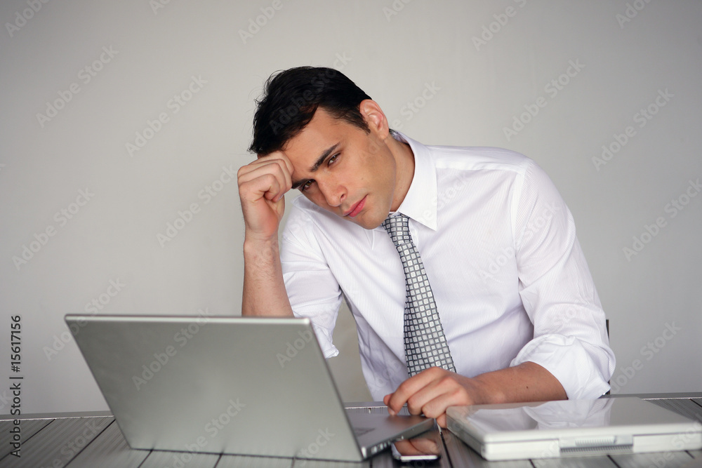 homme réfléchissant assis devant un ordinateur portable homme réfléchissant assis devant un ordinateur portable