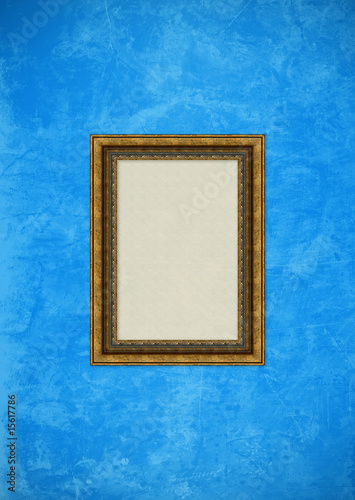 Grunge blue stucco wall with empty picture frame
