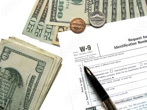 Money tax for W-9 Revenue Tax form closeup, annual money payment, american taxation diversity