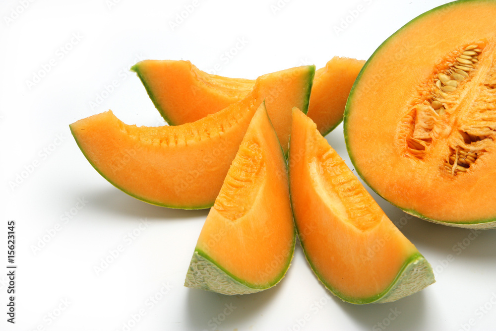 Melon en tranches et un demi-melon sur fond blanc