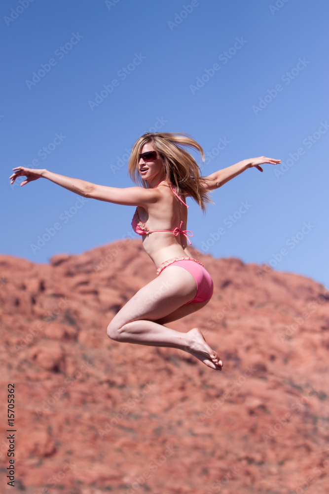 Woman in bikini jumping outdoors Woman in bikini jumping outdoors