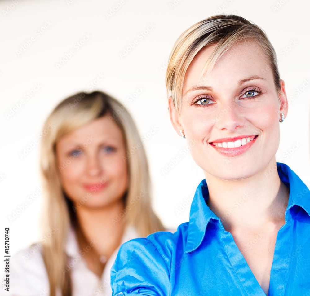 Businesswoman smiling at the camera with her colleague