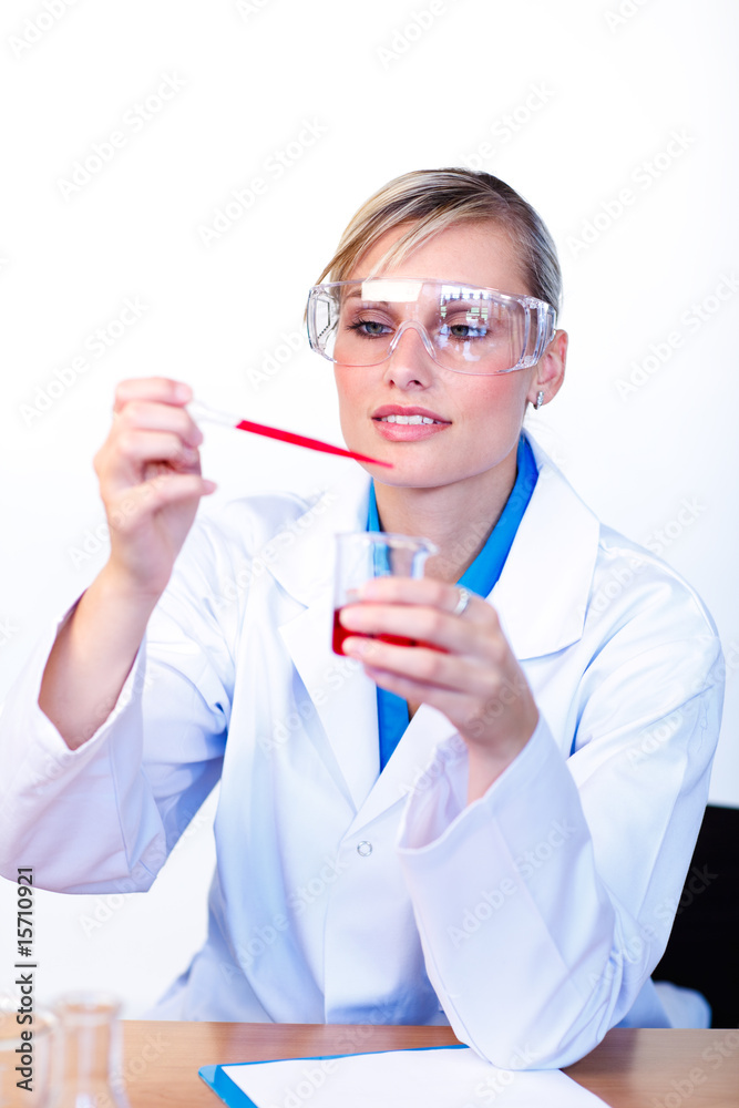 Female scientist examining a test-tube Female scientist examining a test-tube