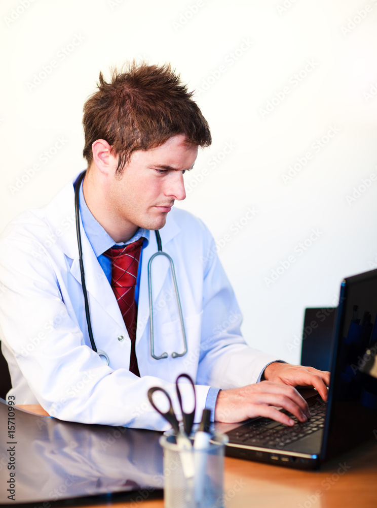 Thoughtful young doctor working on a computer