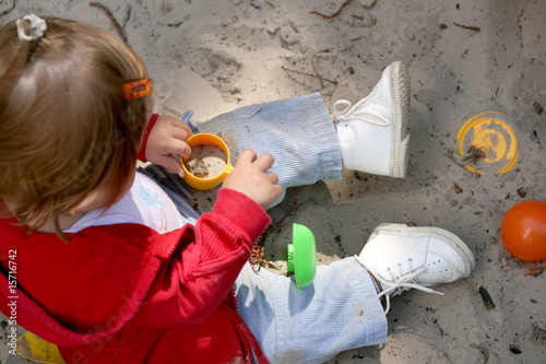 little girl plays in the sand box