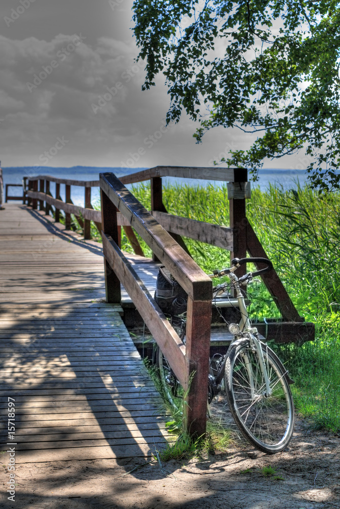 Bikes standing in the front of the wooden pier at the lakeside