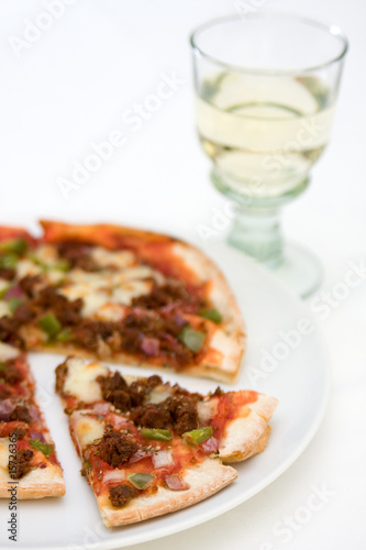 Pizza and glass of white wine on a white background