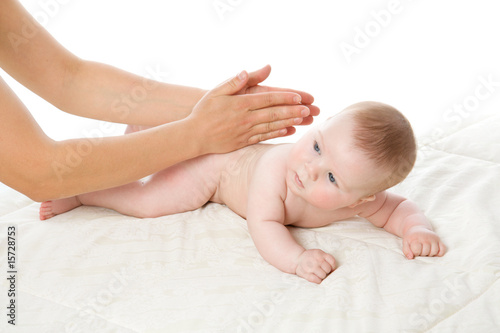 The feminine hands massage the cute baby boy