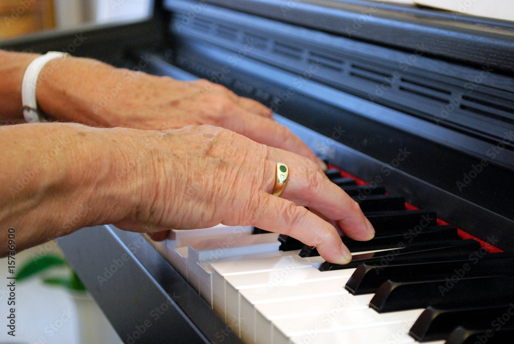 Fototapeta premium elderly woman playing piano