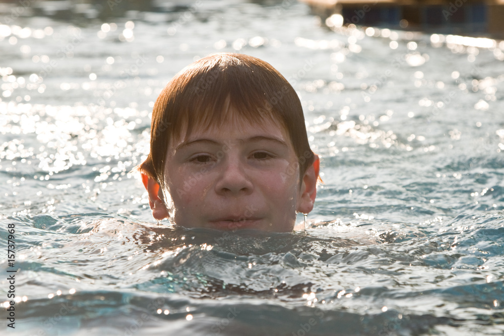 Jugendlicher schwimmt in einem Quellwasser Schwimmbad