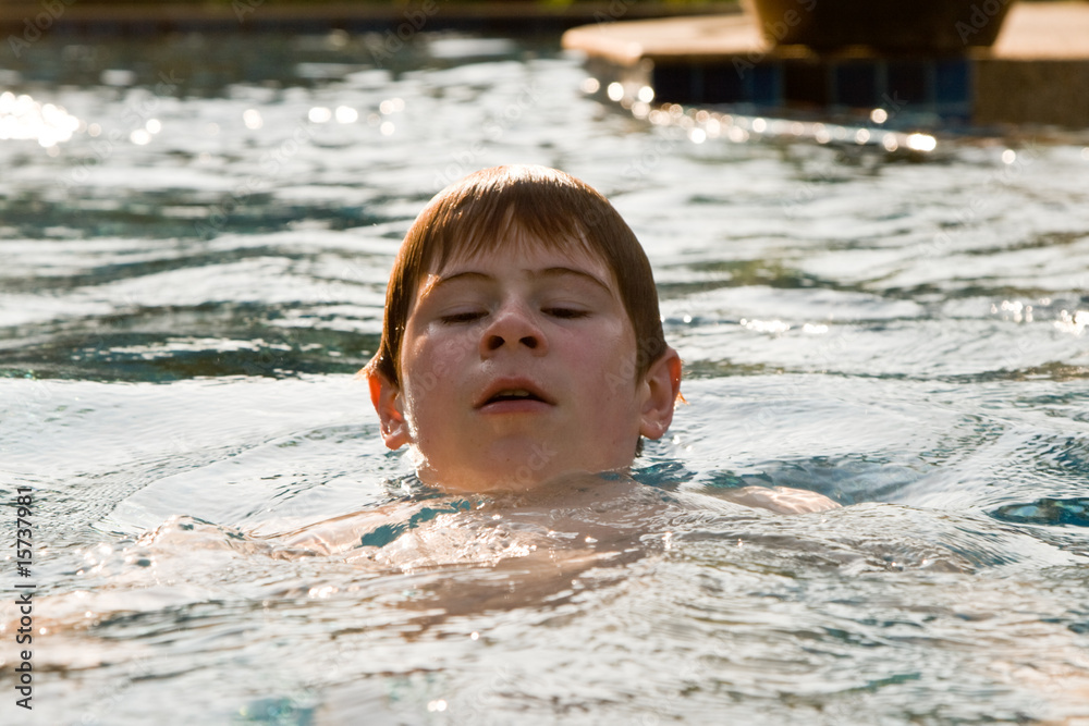 Jugendlicher schwimmt in einem Quellwasser Schwimmbad