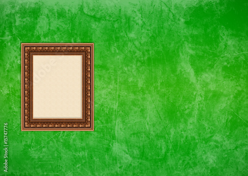 Grunge green stucco wall with empty picture frame