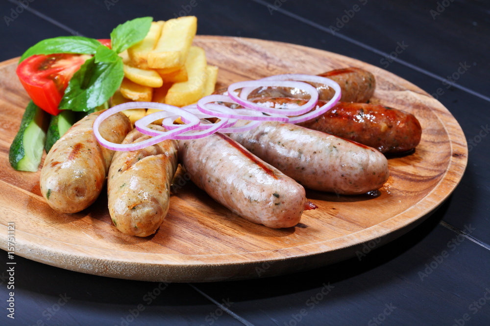 Assortment of grilled sausages on the wooden plate