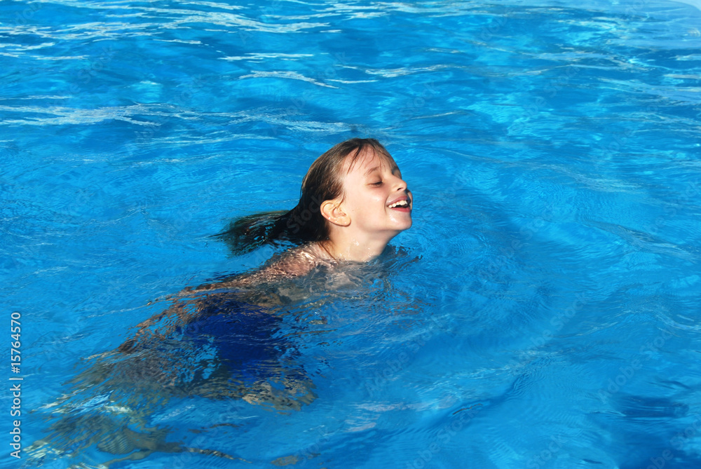 Enfant nageant dans la piscine