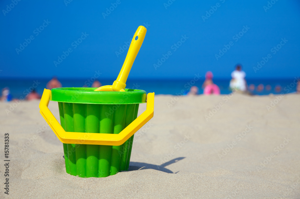 Plastic spade and bucket in sand Plastic spade and bucket in sand