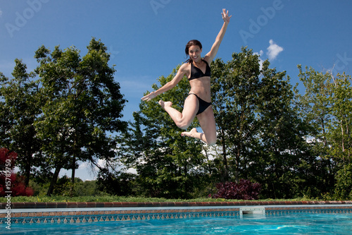 Woman in black bikini jumping into pool