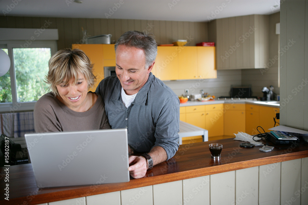 homme et femme souriants devant un ordinateur portable homme et femme souriants devant un ordinateur portable
