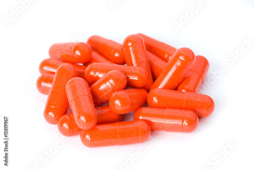 Heap of red pills capsules or drugs on white background
