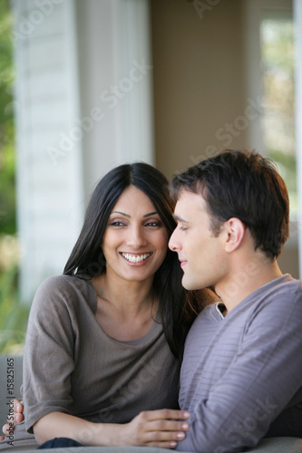 homme et femme souriants assis sur un canapé