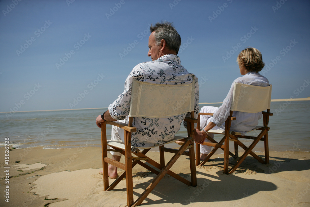 Homme et femme assis face à la mer