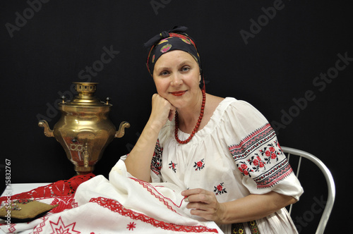 Lady embroiderer in traditional Ukrainian clothes on black photo