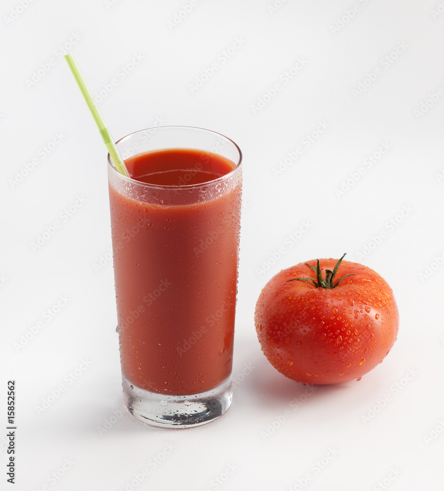 Glass with fresh tomato juice near the tomato Glass with fresh tomato juice near the tomato