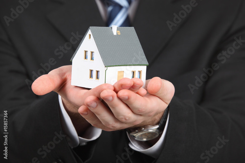 hands with model of house